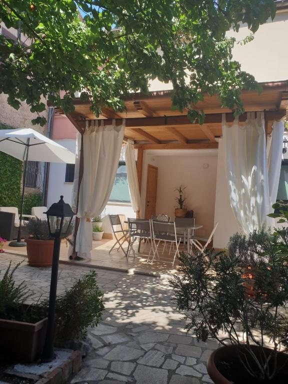 a patio with a table and chairs under a pavilion at IL GIARDINETTO di Dilyana in Monterosi
