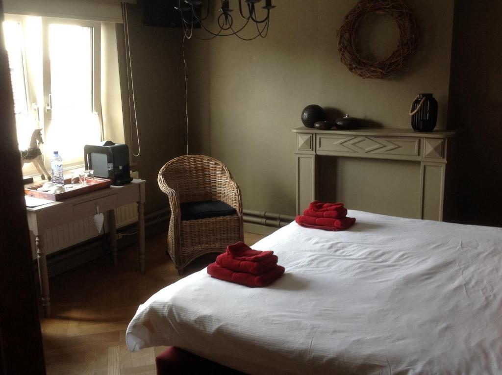 a bedroom with a bed with red towels on it at Guesthouse &#39;t Goed Leven in Stokrooie