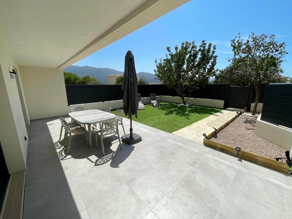 un patio avec une table et un parasol dans l'établissement Casa Di Lucianu, à Casaglione