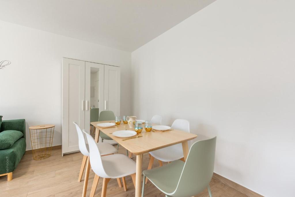 a dining room with a wooden table and white chairs at BIG BEN Near Disneyland Paris - Fairytale Factory in Bussy-Saint-Georges