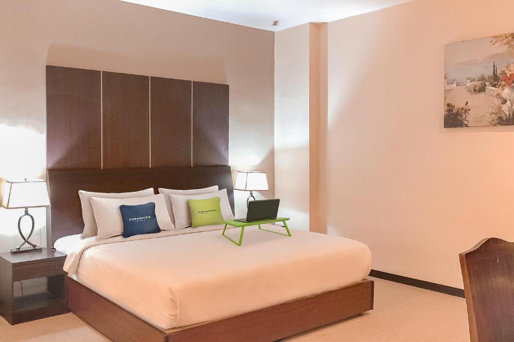 Urbanview Hotel Grand Permata In Banjarbaru by RedDoorz tesisinde bir odada yatak veya yataklar