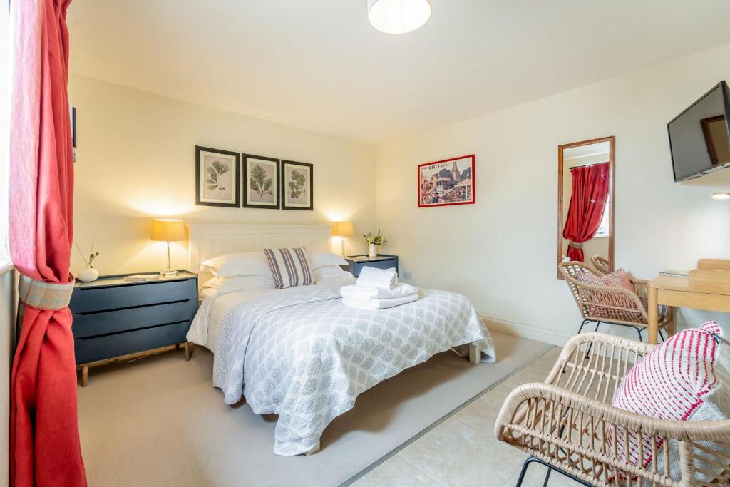 a bedroom with a bed and a table and chairs at The Garden Room in Eastbourne