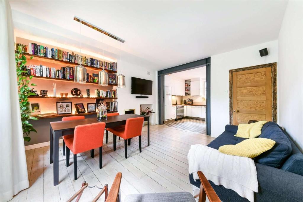 Designer Flat in Bethnal Green في لندن: غرفة معيشة مع أريكة زرقاء وطاولة