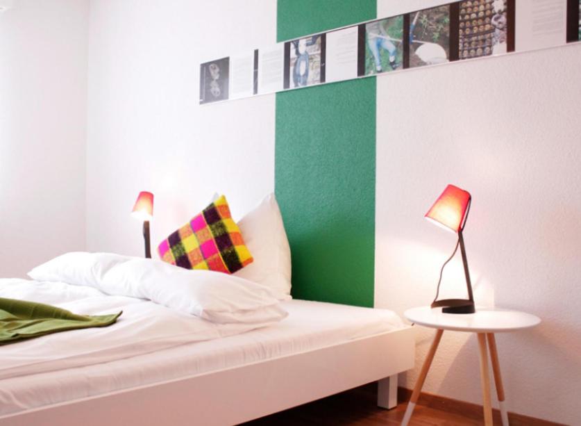 een slaapkamer met een bed met een groene en witte muur bij Nest - Lauriedstrasse 1 in Zug