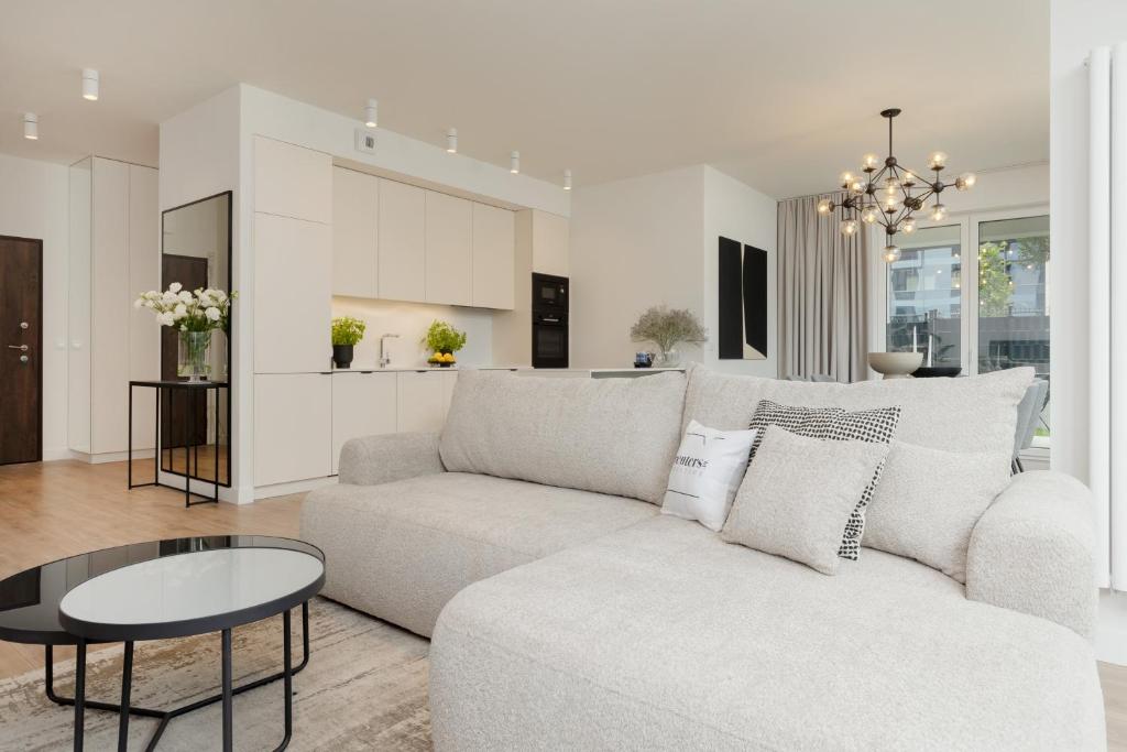 a white living room with a couch and a table at LUX Apartments Domaniewska with Sauna & Gym by Renters Prestige in Warsaw