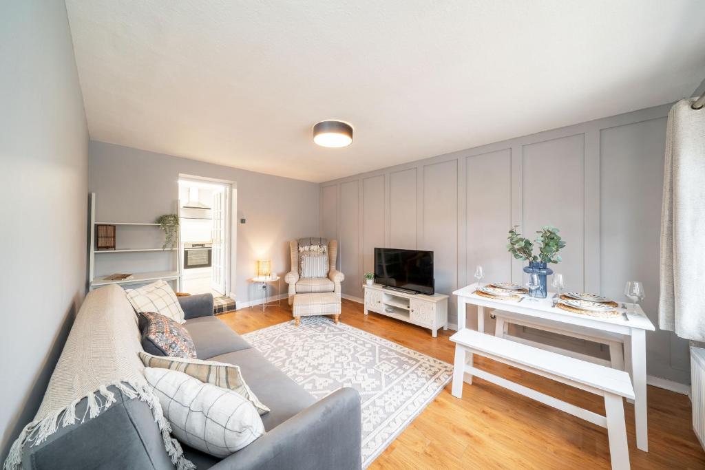 a living room with a couch and a tv at Heatherwood Cottage in New Scone