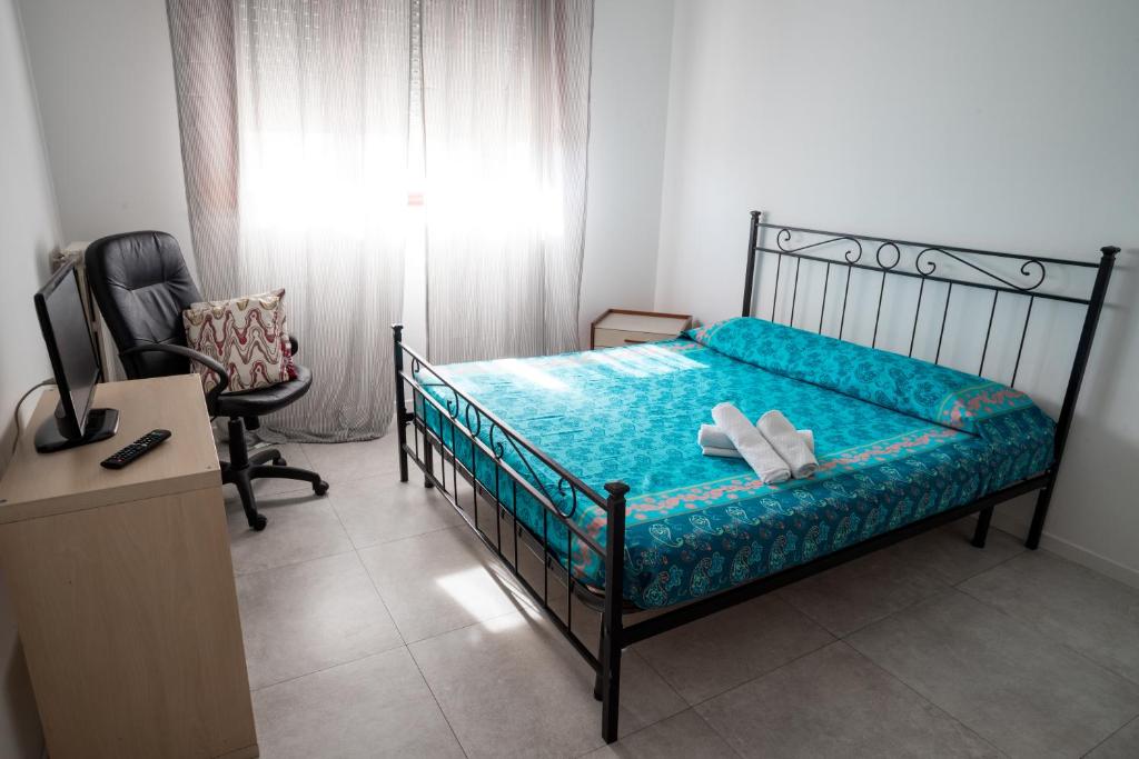1 dormitorio con cama, escritorio y silla en Affittacamere Ortensia, en Lodi