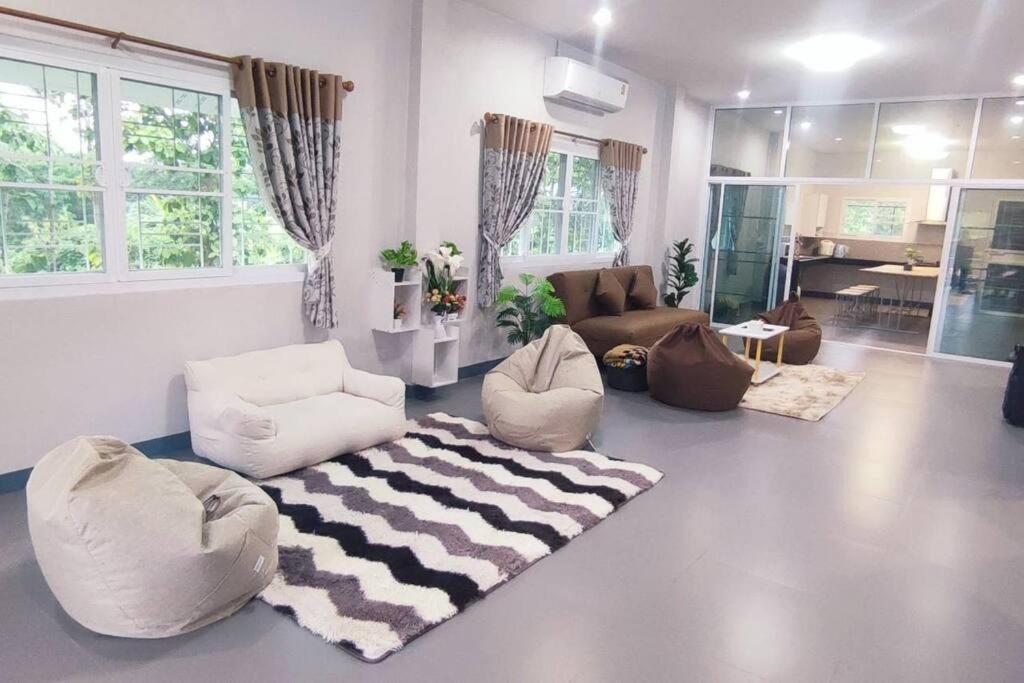 una sala de estar con sofás, sillas y una alfombra. en กิติ์ชาวิว วิลล่า en Ban Nang Lae
