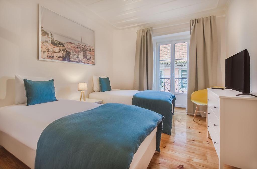 リスボンにあるLisbon City Stay @ Largo do Carmoのベッド2台とテレビが備わるホテルルームです。