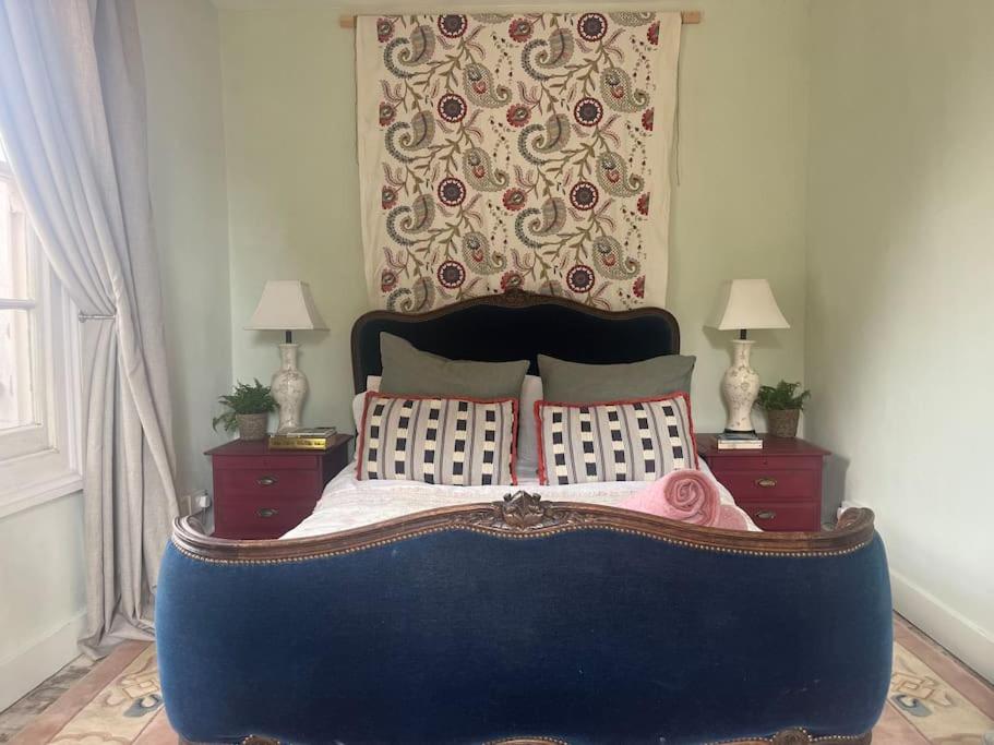 um quarto com uma cama grande e 2 mesas de cabeceira em Garden Sq Bolt hole by the Sea em Kent