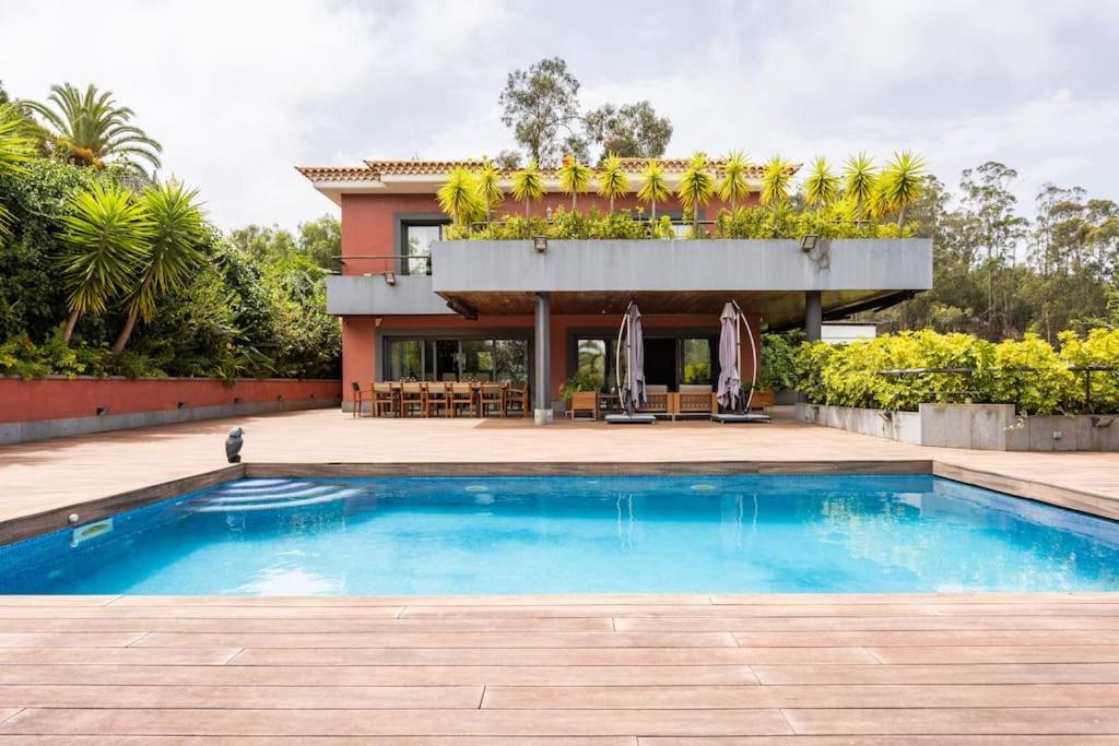 una casa con piscina di fronte a una casa di Casa de lujo junto al Club Golf a Tacoronte