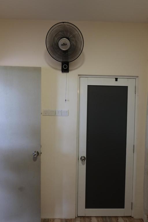 een kamer met een deur en een ventilator aan de muur bij The Somer Campsite in Karak