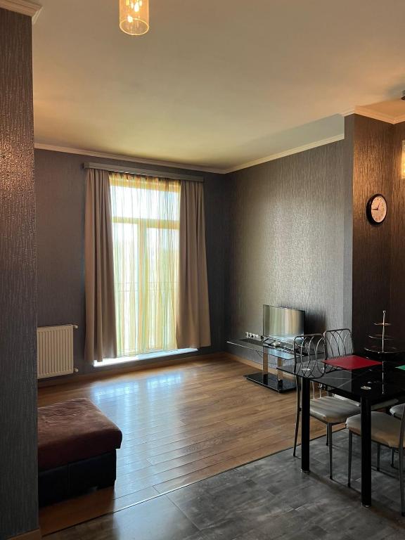uma sala de estar vazia com uma mesa e uma janela em Sunny Apartment in Didi Dighomi em Tbilisi