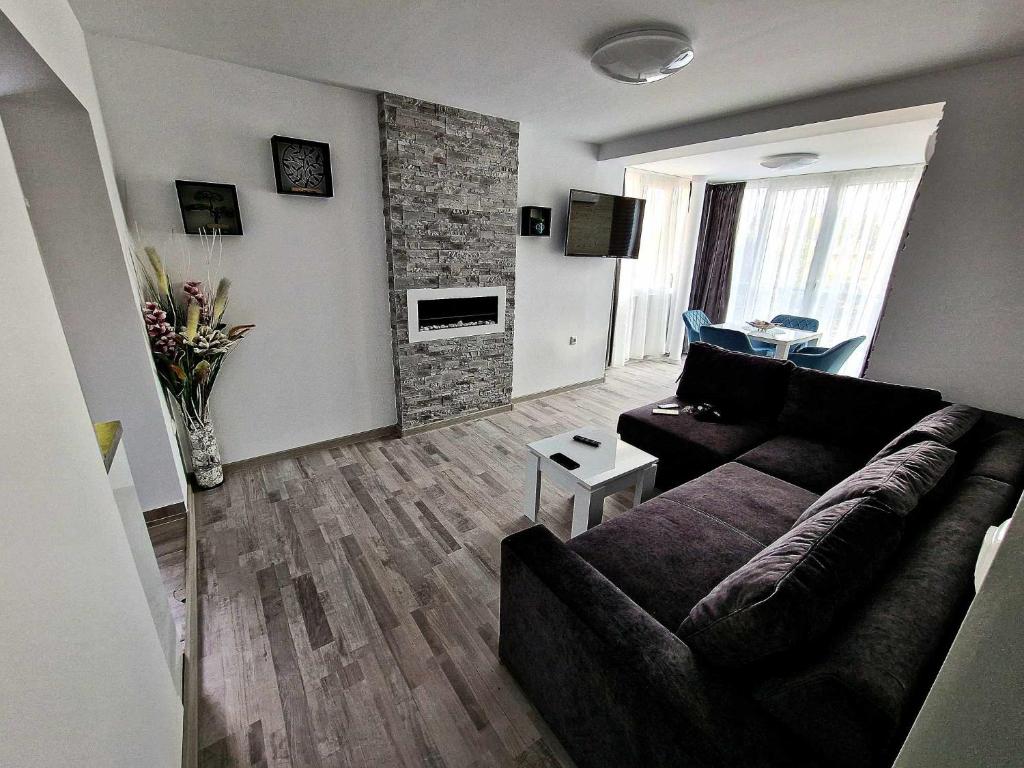 ein Wohnzimmer mit einem Sofa und einem Tisch in der Unterkunft Apartment ''Simon Green'' in Baltschik