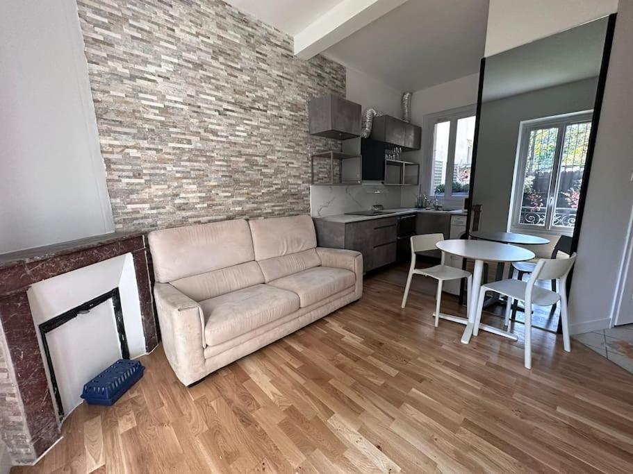 uma sala de estar com um sofá, uma mesa e uma lareira em appartement moderne quai de seine em Neuilly-sur-Seine