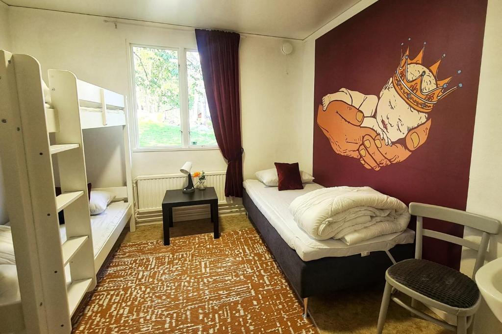 Habitación pequeña con cama con mural en la pared en Orrefors Vandrarhem, en Nybro