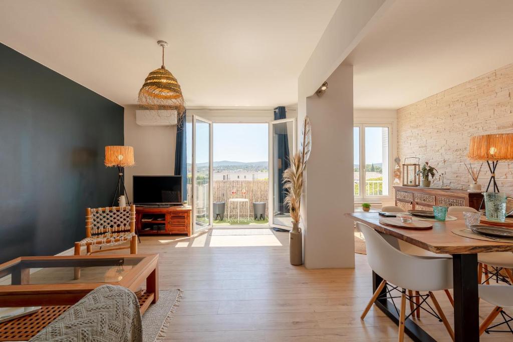 un salon avec une table et une salle à manger dans l'établissement Le Blue Sea - Appt T3 classé 3 étoiles à 650m de la plage, au Lavandou