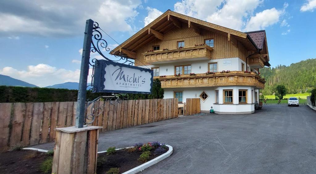 a large building with a sign in front of it at Michis Aparthotel in Flachau