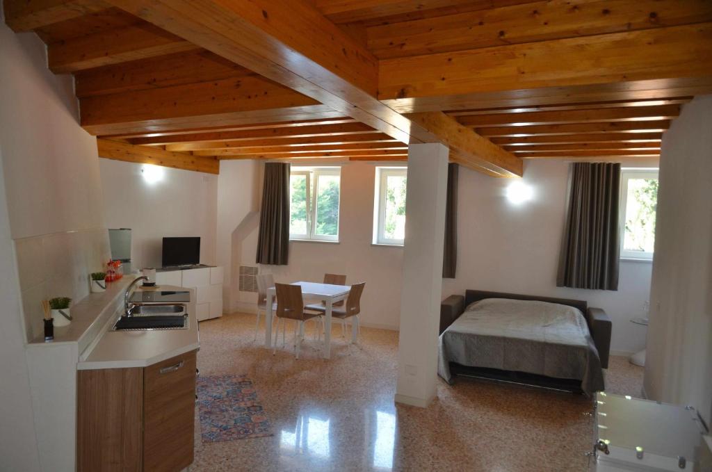 uma cozinha e um quarto com uma cama e uma mesa em Palazzo Maggiore Suite A em Noale