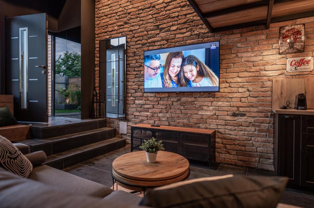 a living room with a tv on a brick wall at The Public Aparthotel 2 in Făgăraş