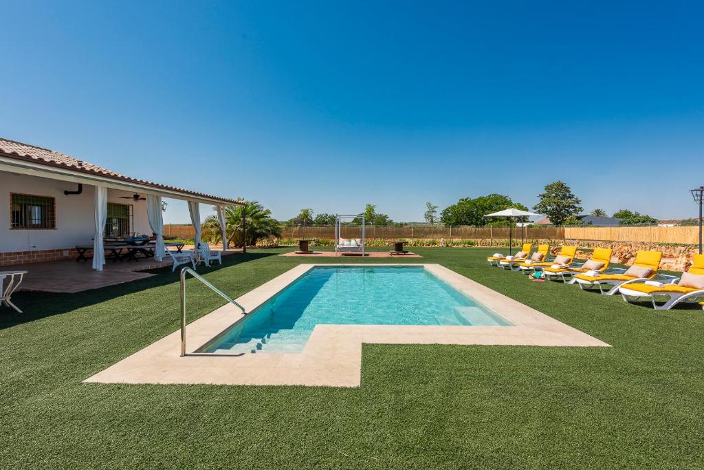 a swimming pool with lounge chairs in a yard at Villa Colona 