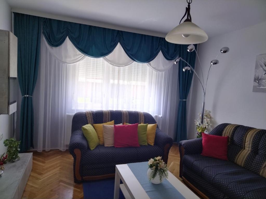 a living room with two couches and a window at Apartman IVA, Donji Miholjac in Donji Miholjac
