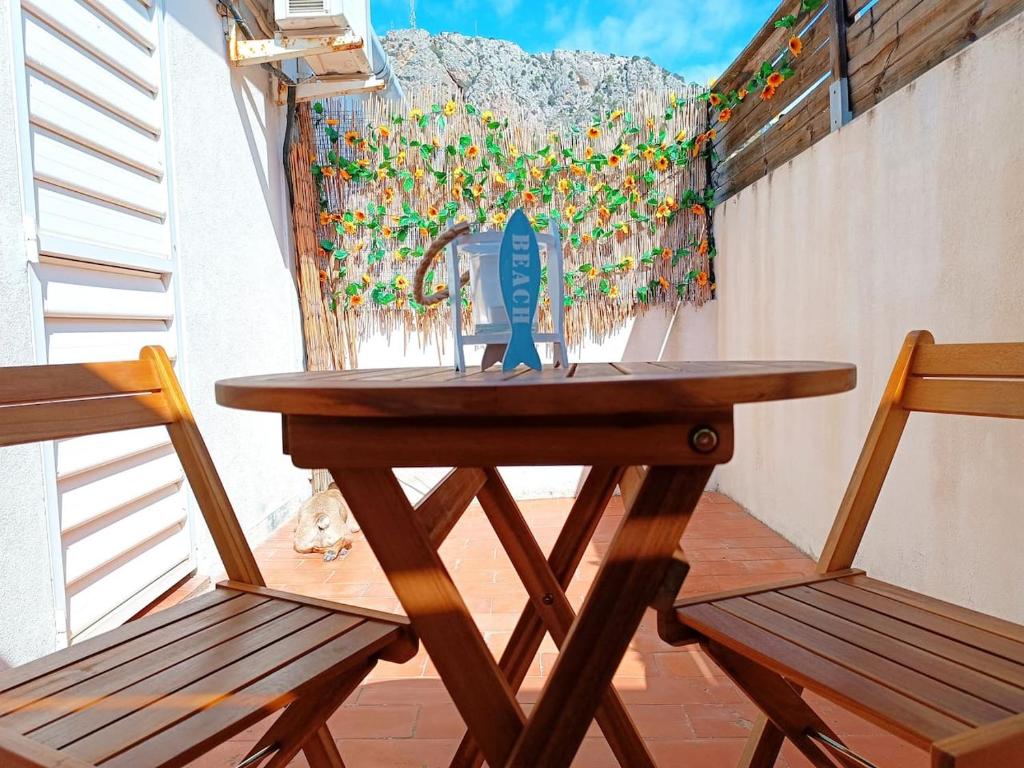a wooden table and two chairs on a balcony at Costa brava apartment, Estartit in Torroella de Montgrí