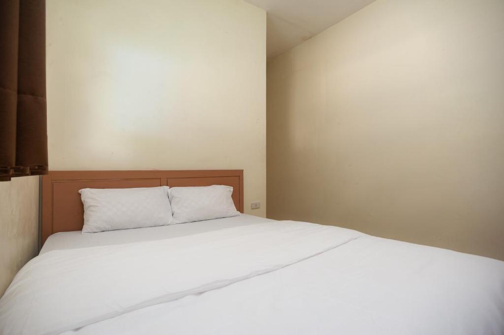 班達楠榜的住宿－AVA Guesthouse Mitra RedDoorz Lampung，卧室配有白色的床和木制床头板