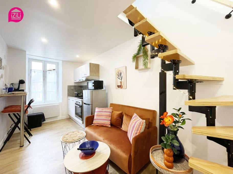 un salon avec un canapé et un escalier en colimaçon dans l'établissement Le Duplex Niortais by CozyLife - Calme et Cosy, à Niort