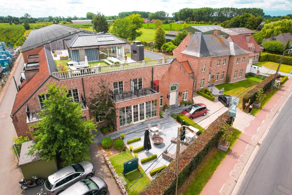 an aerial view of a large brick house with cars parked outside at B&B Fruithof Tack in Sint-Gillis-Waas