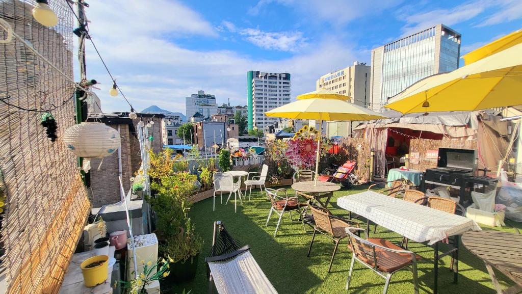 a rooftop patio with tables and chairs and umbrellas at Hi Guesthouse Insadong in Seoul