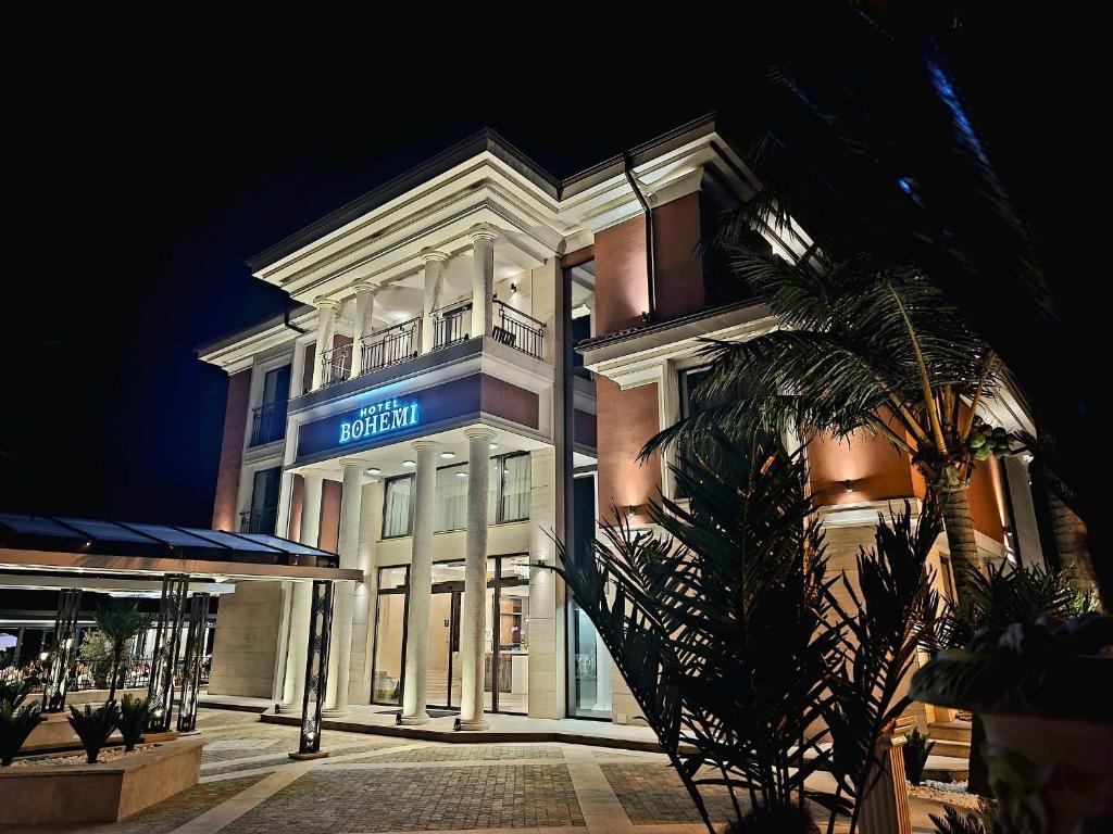 a white building with a blue sign on it at Hotel Bohemi in Haskovo