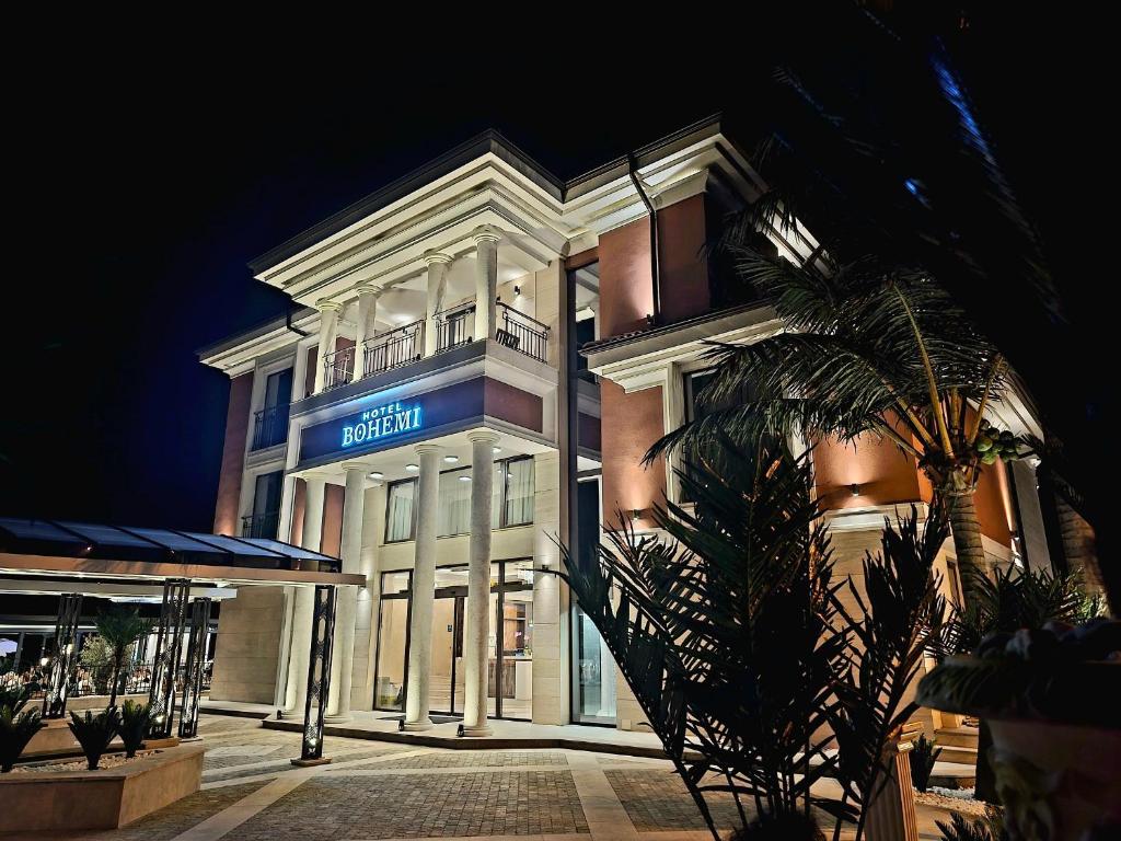 a white building with a blue sign on it at Hotel Bohemi in Haskovo