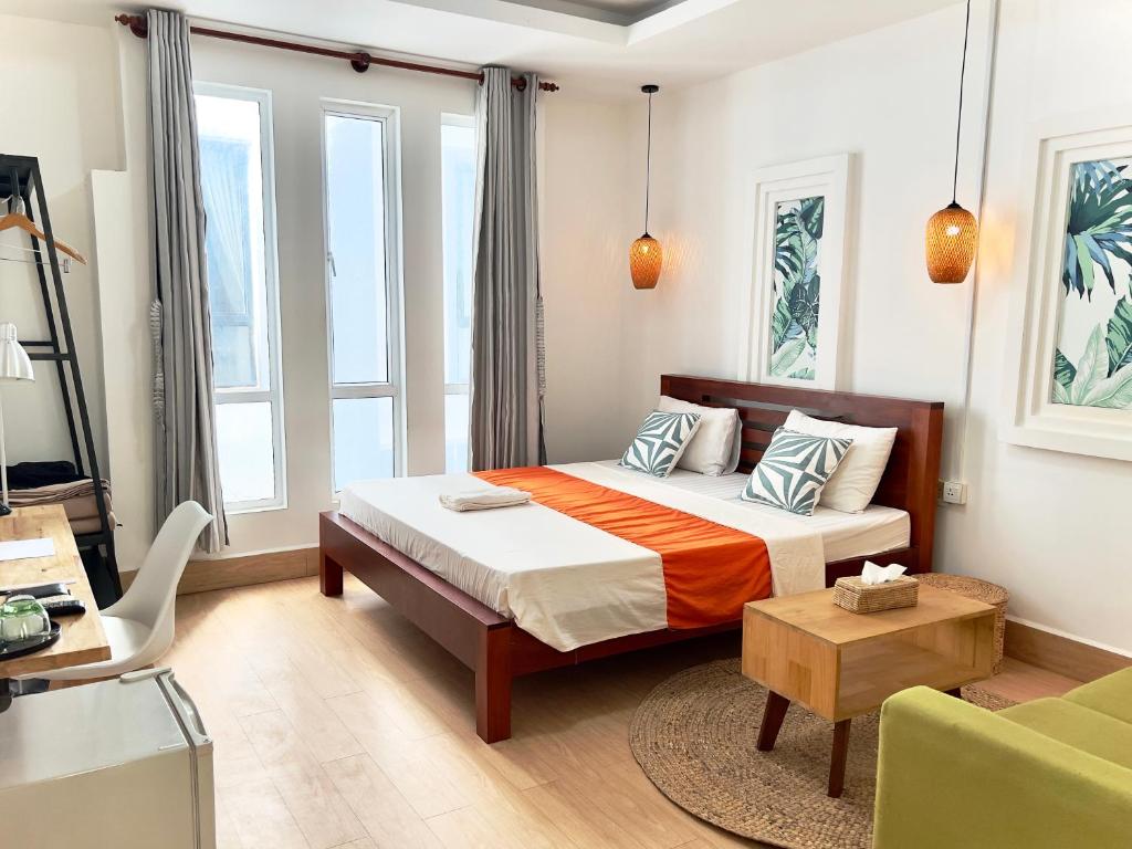 THE PLACE Hostel & Pool Bar في سيام ريب: غرفة نوم بسرير وطاولة ونوافذ