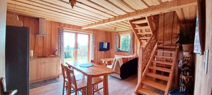 een kamer met een houten huis met een tafel en een ladder bij Domek na Przełęczy in Ochotnica Górna