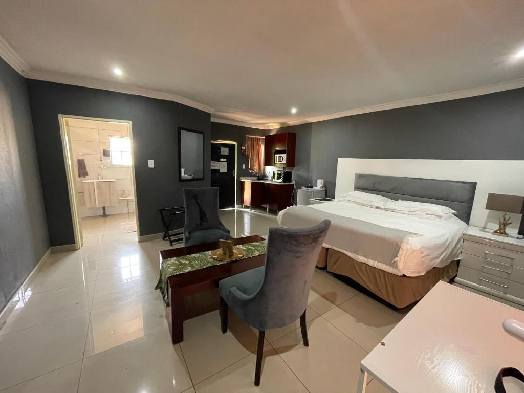 a bedroom with a bed and a table and chairs at 1 OAK Resort in Thohoyandou