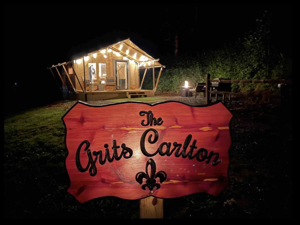 un cartel delante de una casita por la noche en Firefly Season Glamping en Sevierville