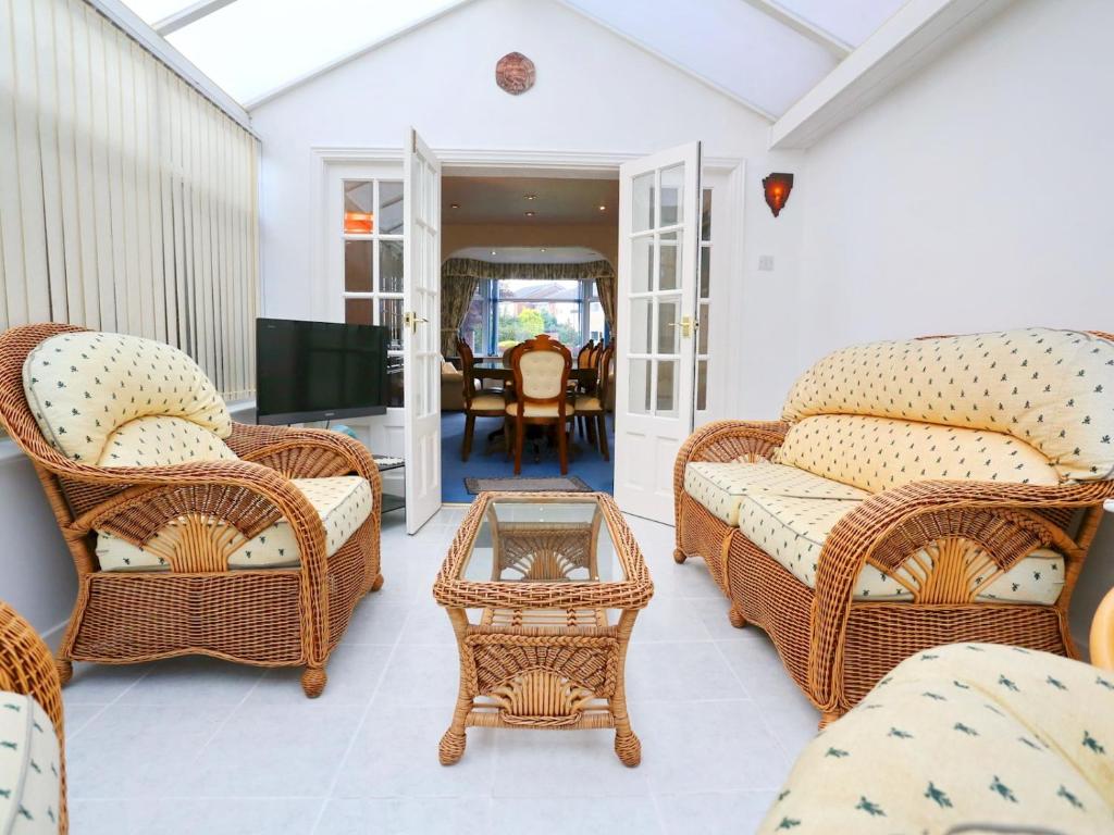 a living room with wicker chairs and a table at Pass the Keys Family Home With Parking Next To Heaton Park in Manchester