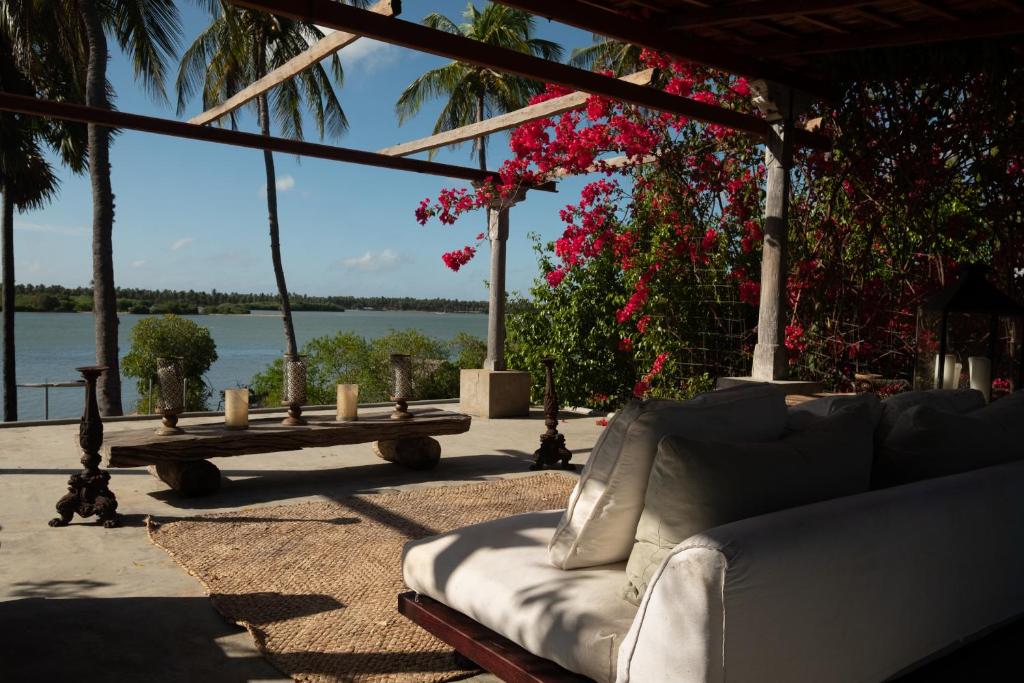 a couch on a patio with a view of the water at Luna Laguna in Kalpitiya