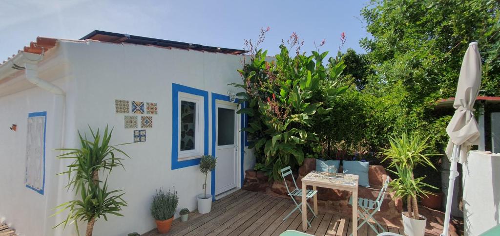 a small white house with a deck with plants at Beautiful house in stunning nature, 22 minutes from beaches, 5 minutes to lake, air condition cool and heat, and very fast Internet in all rooms, dishwasher, washing machine and induction cooking in Silves
