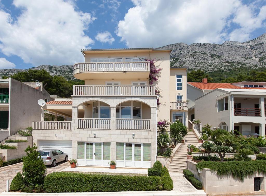 a large house with a balcony on top of it at Apartmens Villa Antonio 88 in Brela