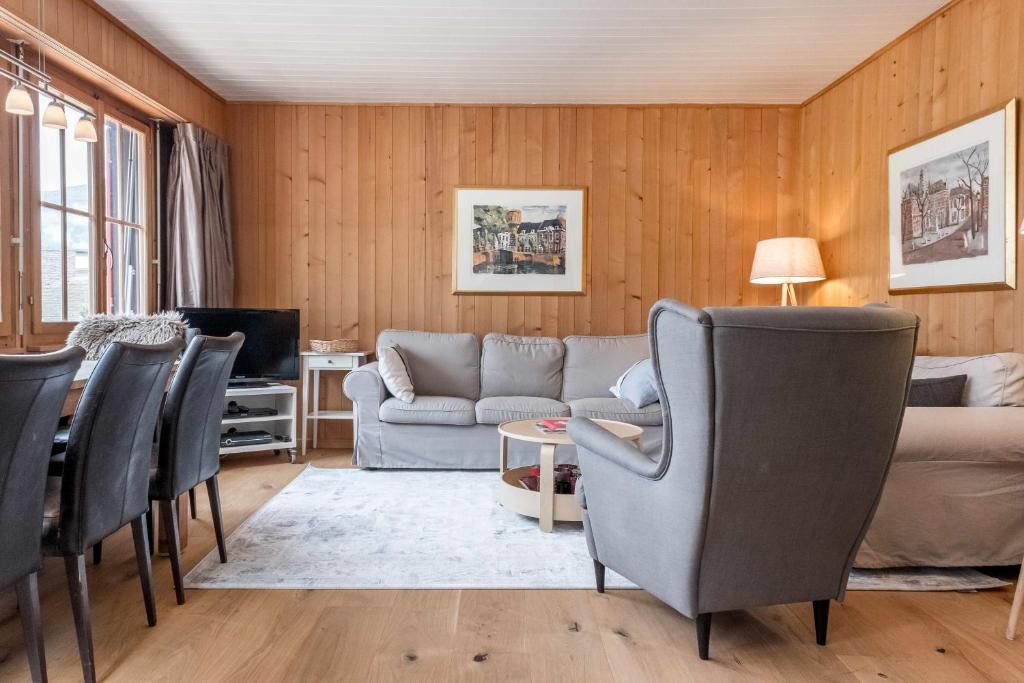 a living room with a couch and chairs at Apartment Zita - GRIWA RENT AG in Grindelwald