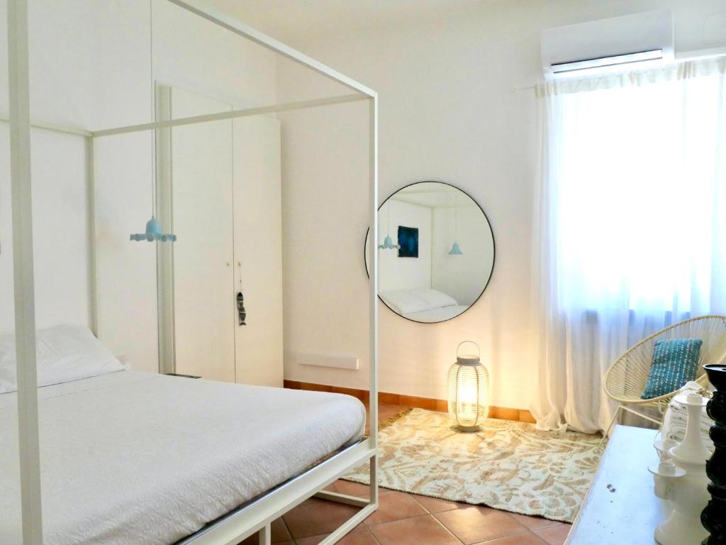 テルモリにあるIl Ciclope - La casa sotto il faroの白いベッドと鏡のある寝室