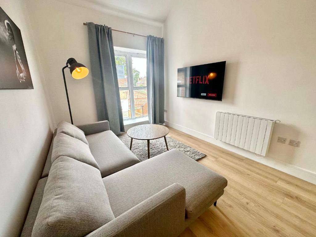 a living room with a couch and a table at Fountain Apartment No 2 with Free Parking in York