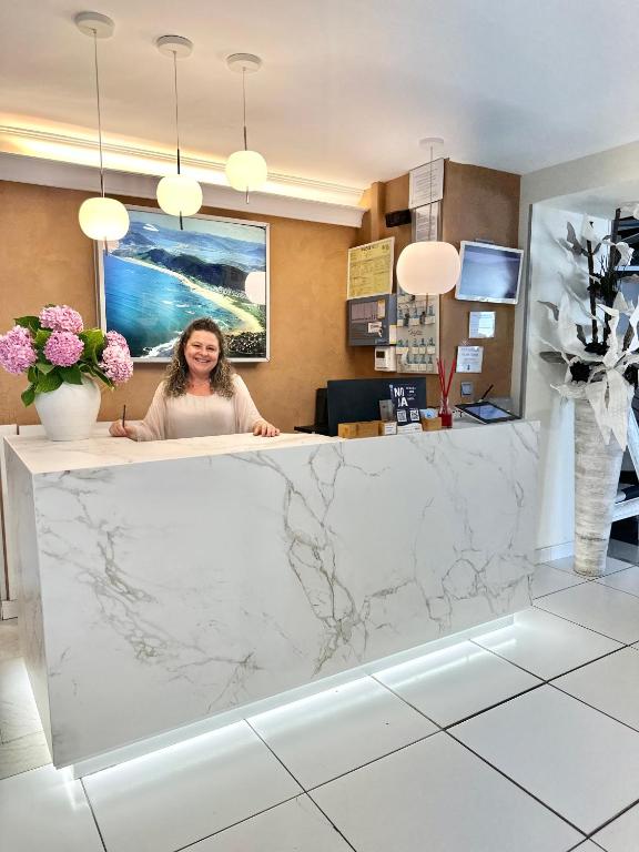 a woman sitting at a counter in a lobby at Hotel Las Olas in Noja