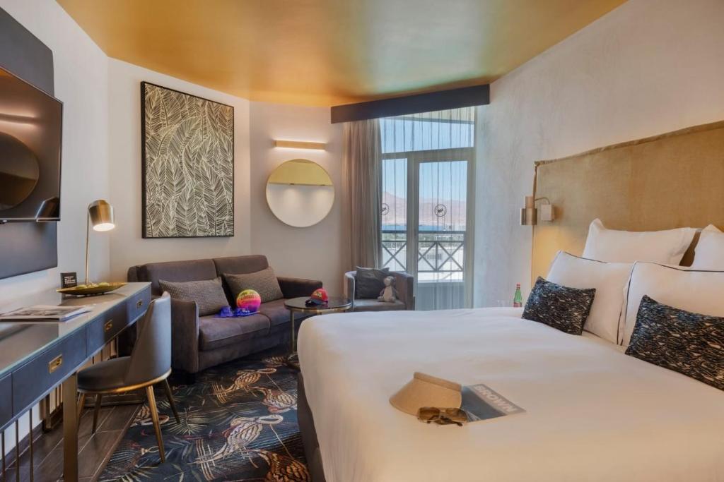 een hotelkamer met een groot bed en een bank bij Brown Lighthouse Eilat, a member of Brown Hotels in Eilat