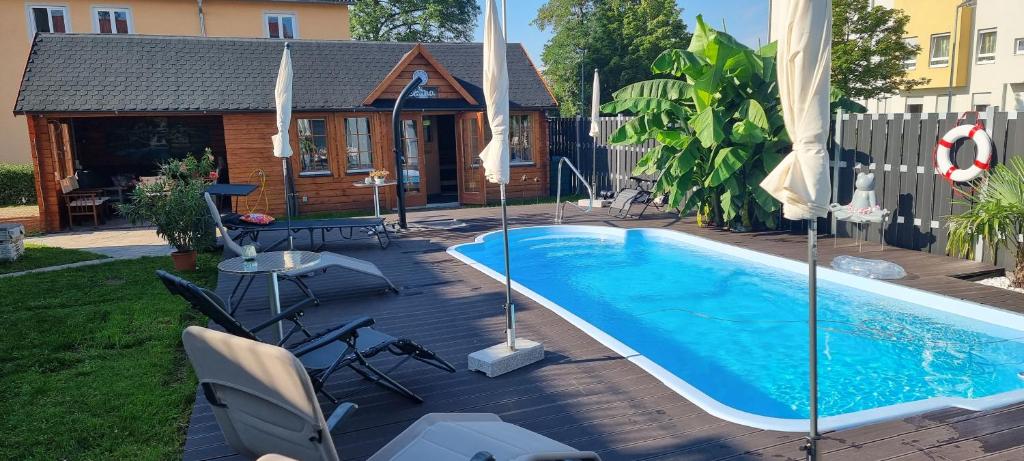 a swimming pool on a wooden deck next to a house at Apartmenthaus Wertheim in Wertheim