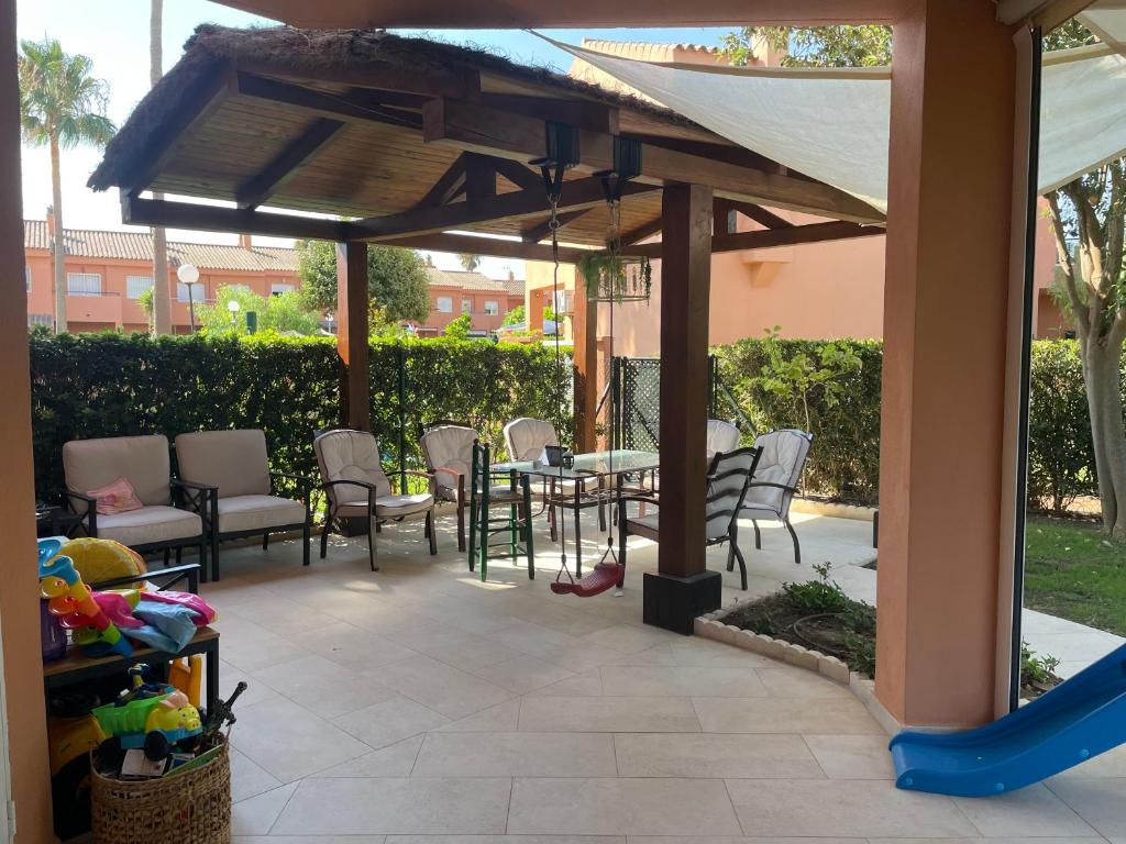 eine Terrasse mit einem Tisch und Stühlen unter einem Pavillon in der Unterkunft Manilva Beach: Your Costa del Sol Getaway! in Castillo de Sabinillas