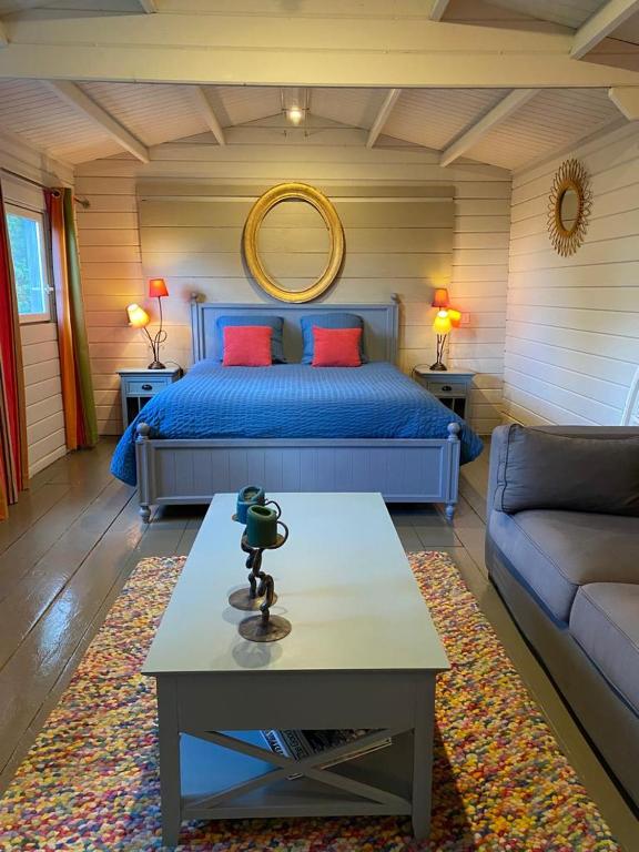 ein Schlafzimmer mit einem Bett, einem Tisch und einem Sofa in der Unterkunft Tiny House au coeur des Combes in Seillans