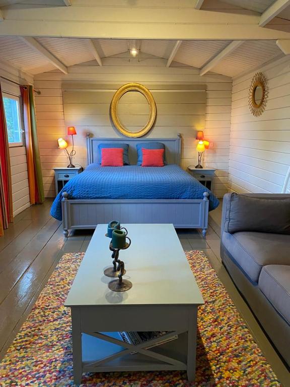 1 dormitorio con cama, mesa y sofá en Tiny House au coeur des Combes, en Seillans